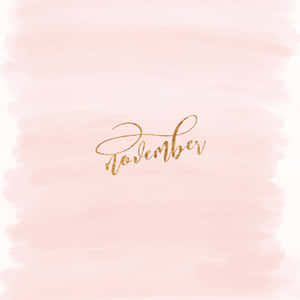 在粉紅色水彩背景上以金色草書寫成的November。 — iPad Pro 11 壁紙