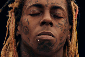 特寫一名有紋身、辮子和閉上眼睛的男子。 — Lil Wayne 壁紙