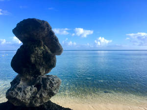 熱帶海灘上堆疊的石頭，平靜的海面和藍天
