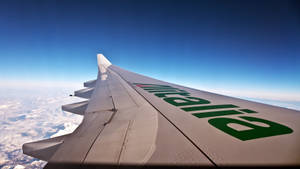 飛機機翼飛越雪山和雲層。 — 天空 壁紙
