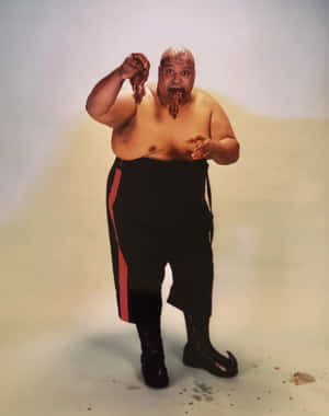 一個穿著帶有紅色條紋黑色褲子的男人正在吃肉，醬汁從他的嘴裡滴下來。