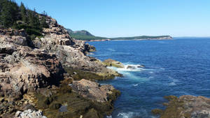 崎嶇海岸懸崖，拍岸浪濤和清澈藍天。