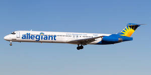 Allegiant Air 飛機放下起落架在清澈藍天中飛行