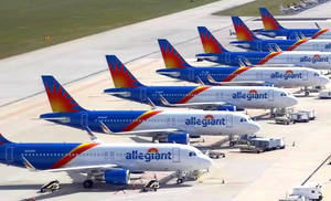 Allegiant Airlines 的飛機一排排停在陽光明媚的機場停機坪上。