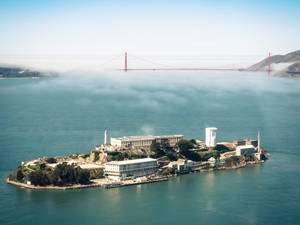 阿爾卡特拉斯島上的監獄建築和金門大橋，籠罩在霧氣中的海灣。