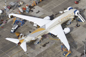 阿提哈德航空飛機停泊在機場閘口，附近有服務車輛。