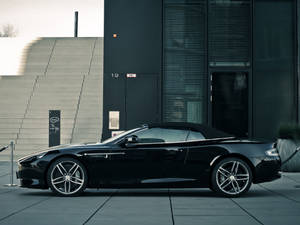 黑色Aston Martin開篷車停泊在現代建築前