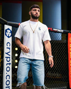 MMA拳手身穿白色T恤和破洞牛仔褲，身處八角籠內。