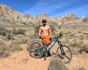 運動型單車手在沙漠景觀中與山地自行車合影。