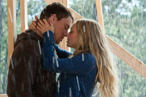 一對情侶在室內接吻，窗外下著雨。