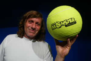 男子拿著標有Monster Tennis Ball的巨型黃色網球 — 網球 壁紙