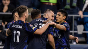 足球員在夜間球場慶祝入球。 — 運動 壁紙