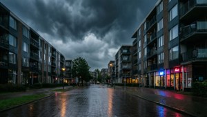 夜晚下雨的城市街道，霓虹燈光在公寓大樓之間的濕漉漉的人行道上反射。