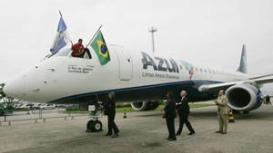Azul Airlines飛機，駕駛艙上有國旗，人們在停機坪附近走動。