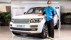 身穿藍色外套的男子在陳列室與白色Range Rover合影。 — 酷車 壁紙