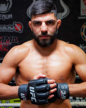 一位專注的男性MMA拳手在健身房中戴著UFC手套。 — 健身 壁紙