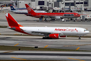 Avianca Cargo 飛機在機場跑道上滑行，背景有其他飛機。