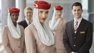 微笑的航空公司員工穿著制服站在機場航站樓。 — 飛機 壁紙