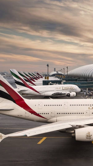 阿聯酋航空飛機在金色日落時停泊在機場客運大樓。