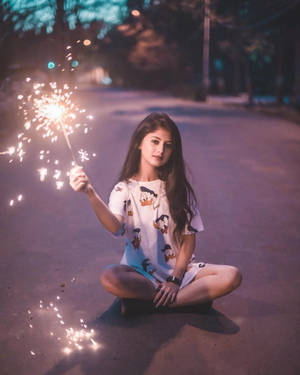 年輕女性夜晚坐在街上手持仙女棒