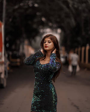 身穿亮片連衣裙的女性在城市街道上擺姿勢
