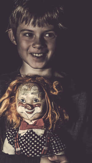 一個微笑的男孩抱著一個復古小丑娃娃，娃娃有蓬鬆的頭髮和波點連衣裙。