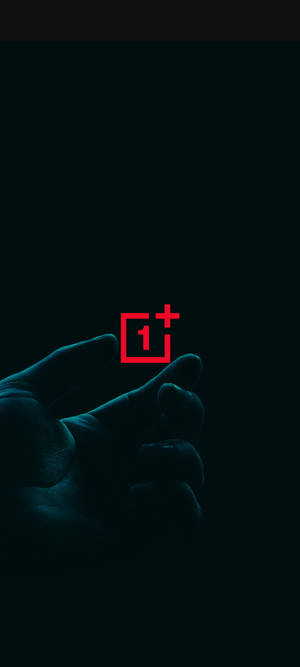手在深青色背景上拿著發光的紅色OnePlus標誌 — Pixel 9 Pro Fold 壁紙