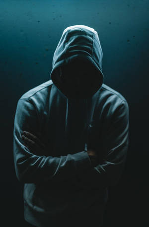 匿名人士穿著連帽衫，在藍光下臉部隱藏在陰影中。
