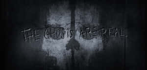 裂縫牆上的塗鴉在昏暗燈光下寫著「THE GHOSTS ARE REAL」。 — 使命召喚：現代戰爭 壁紙