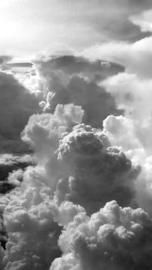 暴風雨天空中戲劇性且帶有紋理的雲朵盤旋的單色航拍視圖。