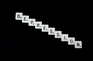 白色 Scrabble 字母磚在黑色背景上拼出 depression