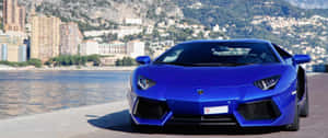 藍色林寶堅尼Aventador停在水邊，後面有摩納哥建築物。 — 3440x1440 壁紙