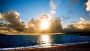 海洋上的夕陽，有雲和卵石海灘 — 寒冷 壁紙