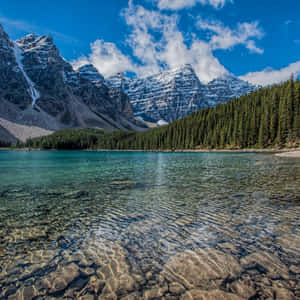 寧靜的高山湖泊，湖水清澈，藍天下有白雪覆蓋的山峰。