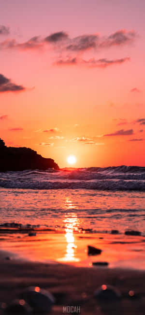 夕陽映照海洋，海浪拍打岩石海岸