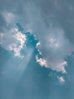 陽光穿過散落的雲層，照耀在清澈的藍天上。 — Samsung S23 Ultra 壁紙
