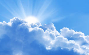 太陽在清澈的藍天中透過白雲明亮地照耀。