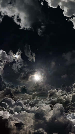 月亮透過烏雲照耀，夜空中可見星星。