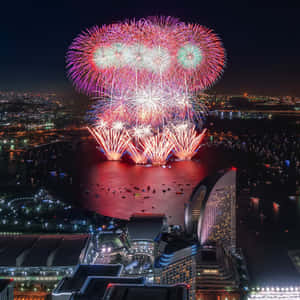 五彩繽紛的煙花在夜間的城市天際線和水面上綻放。