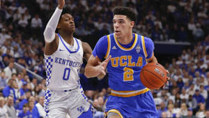 UCLA籃球運動員在擠滿觀眾的場館中運球越過肯塔基防守球員。