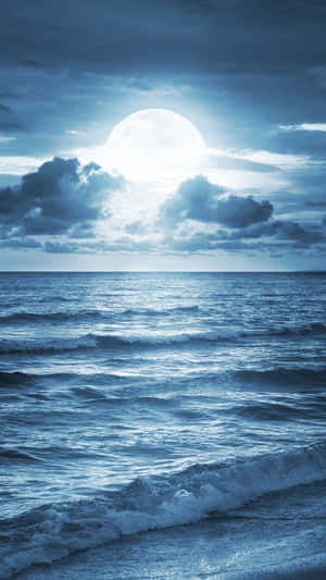 月光照亮了多雲夜空下翻騰的海浪。