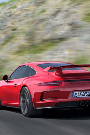 紅色保時捷911 GT3在日落時分於山路高速行駛