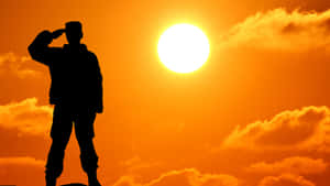 士兵在橙色天空和雲朵的日落中敬禮 — 軍事動圖 壁紙