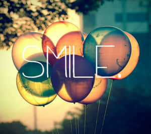 色彩繽紛的氣球，SMILE 字樣在日落時透過它們閃耀。