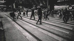 行人穿過有電車軌道的街道，在繁華的城市中。