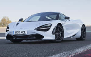 白色McLaren 720S跑車在賽道上，配備黑色輪圈和空氣動力學設計。