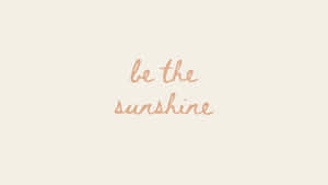 勵志名言 be the sunshine 以柔和蜜桃色草書呈現於奶油色背景上