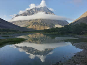 山峰倒映在寧靜的湖泊中，上下皆有雲霧。