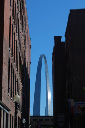 Gateway Arch 被磚砌建築物框住嘅日落景色