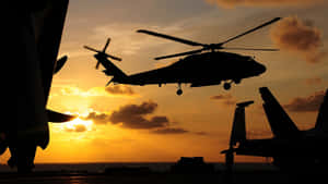 夕陽下直升機在航空母艦上盤旋的剪影 — 直升機 壁紙
